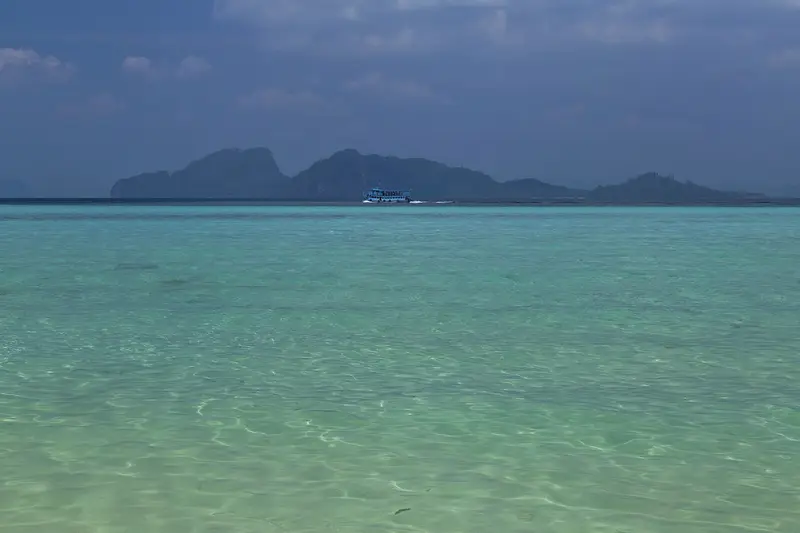 Clear turquoise water off Ko Kradan, with limestone islands on the horizon